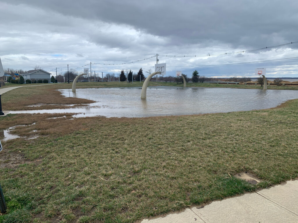 a body of water with grass and a bridge in the background (MyCoast AI)