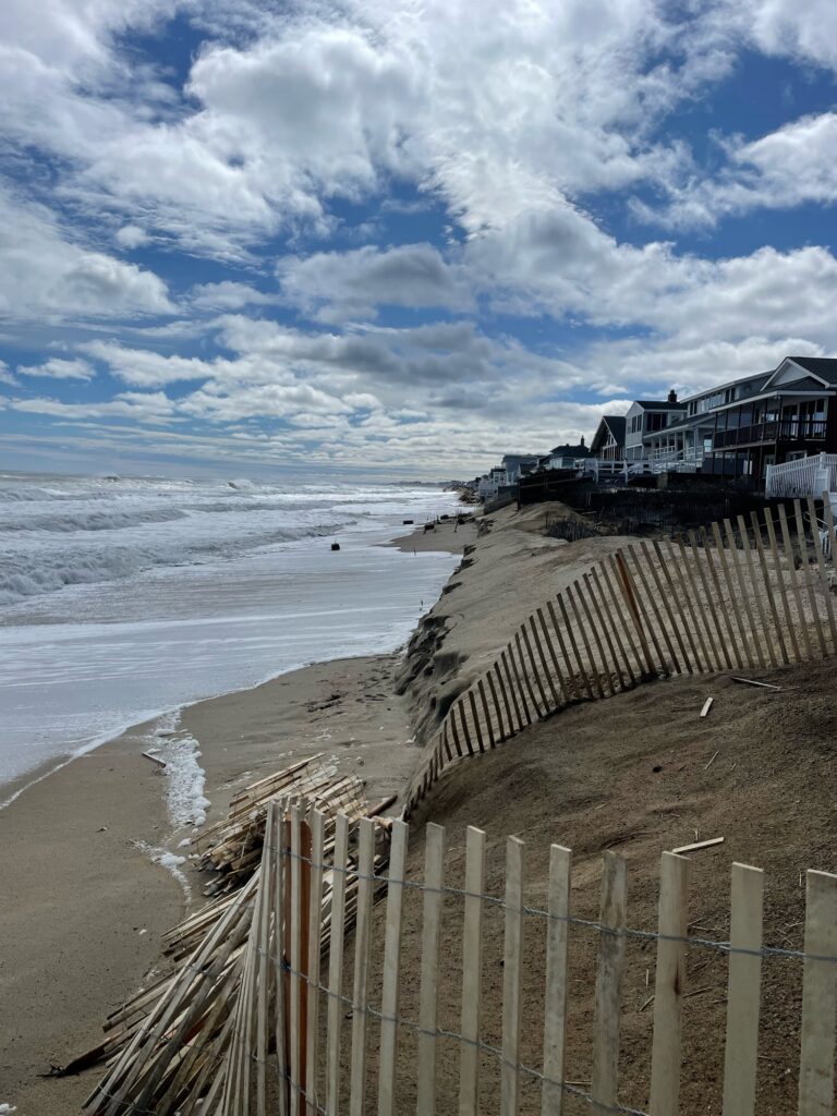 a beach with a fence and a building on the shore (MyCoast AI)