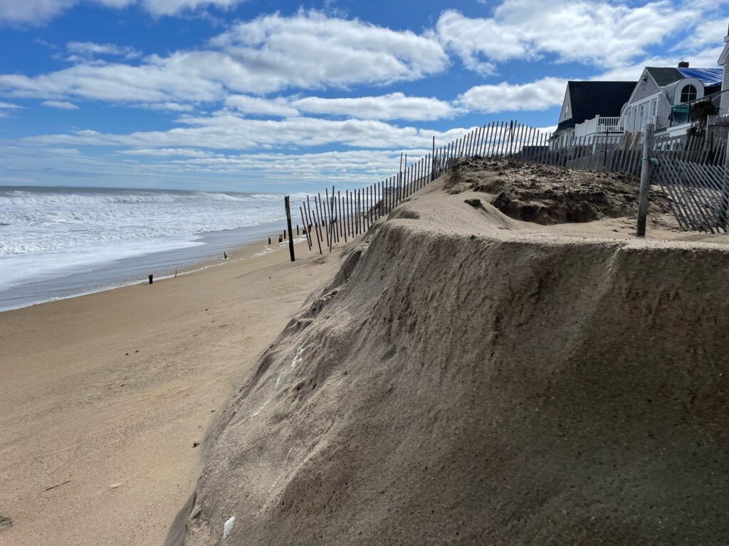 a beach with a fence and a house on the shore (MyCoast AI)