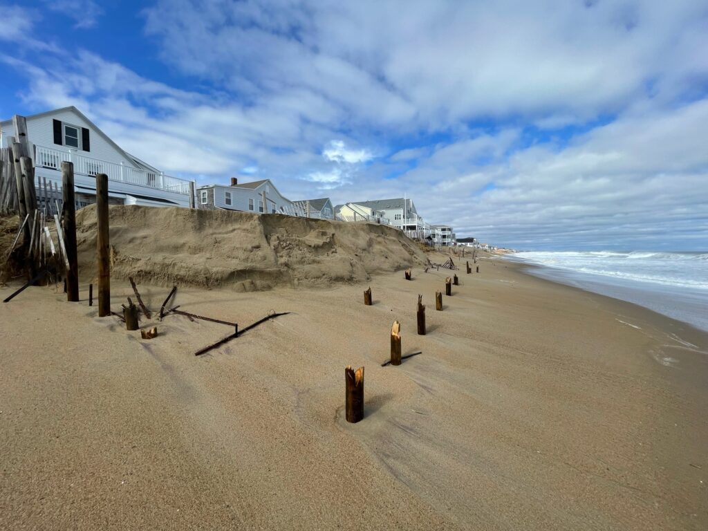 a beach with a fence and a building on the other side (MyCoast AI)