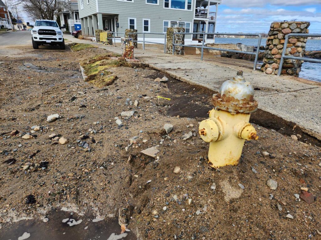 a yellow fire hydrant in a dirt yard (MyCoast AI)