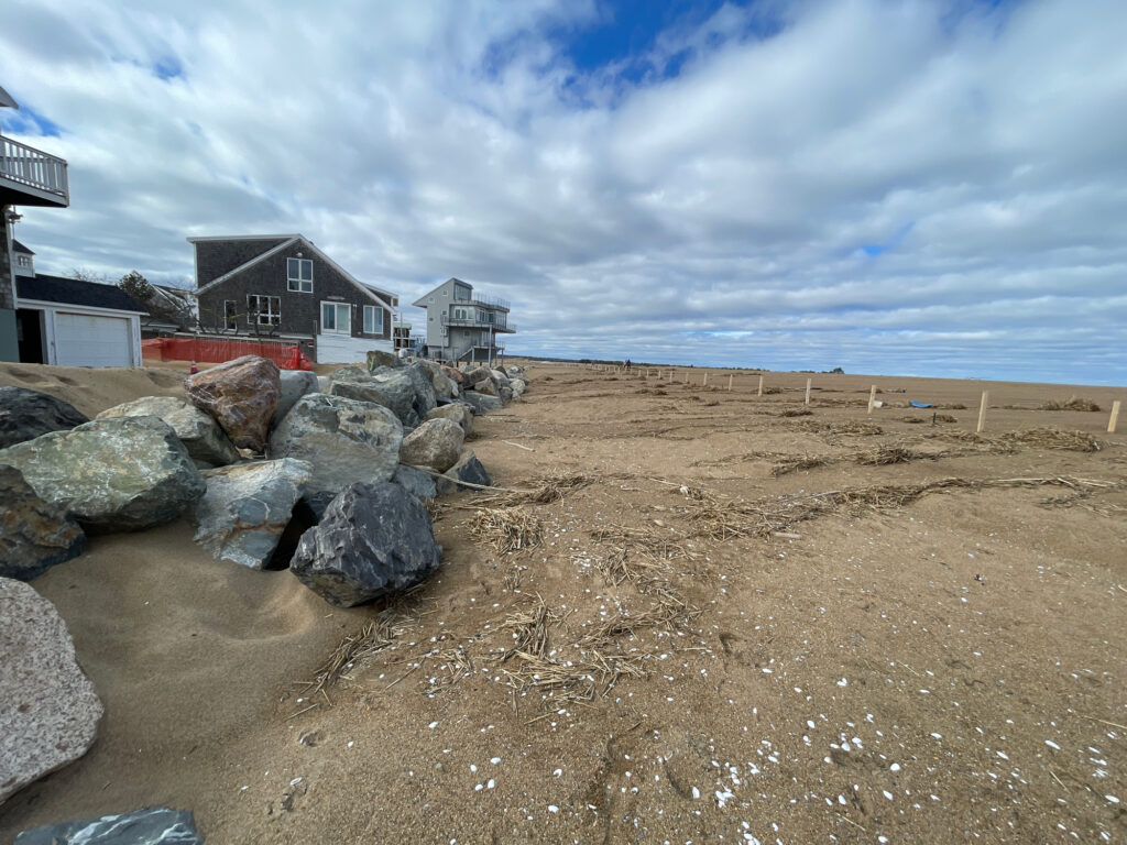 a rocky beach with a house in the background (MyCoast AI)
