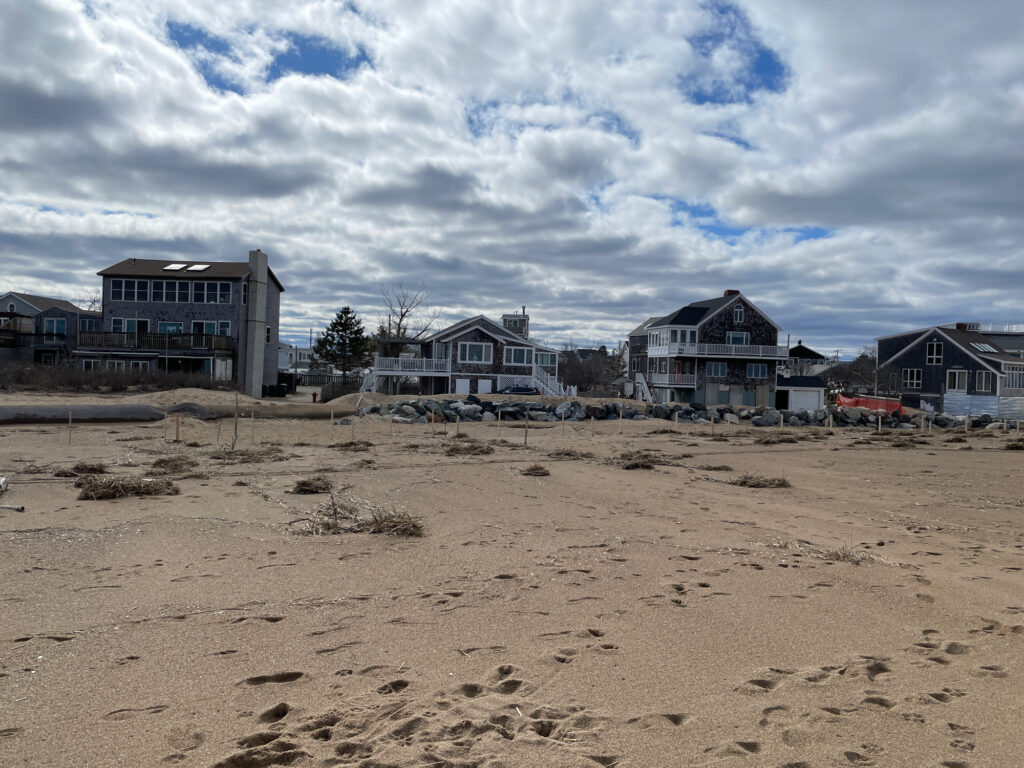 a sandy beach with houses in the background (MyCoast AI)