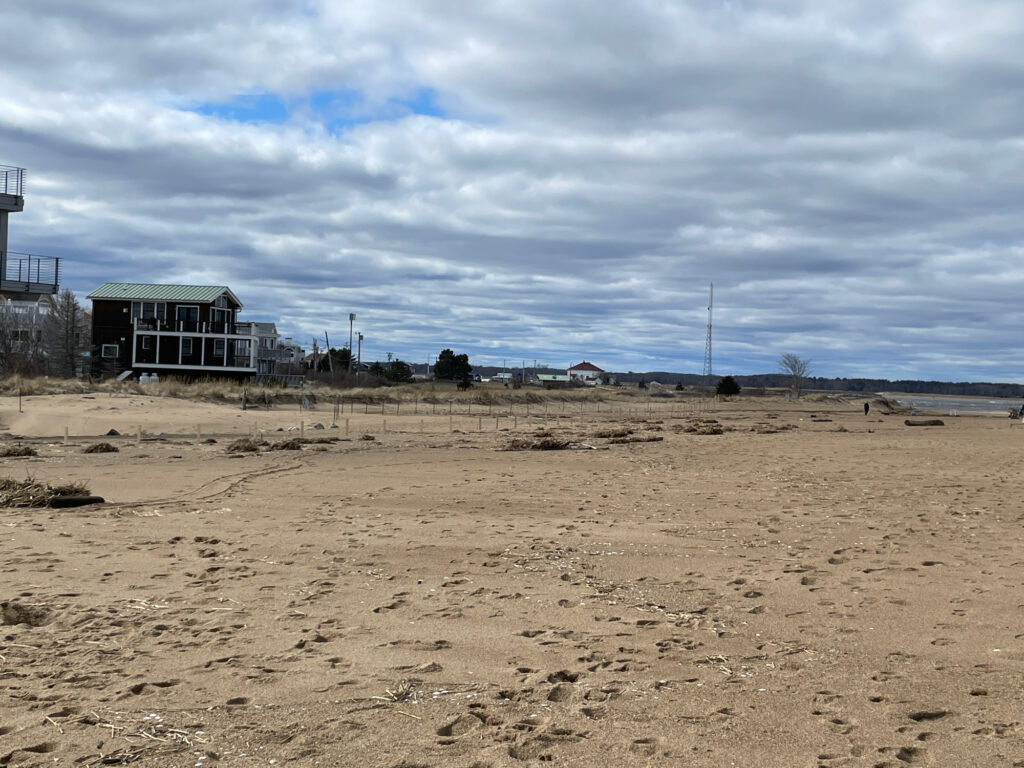a large dirt field with a building in the distance (MyCoast AI)