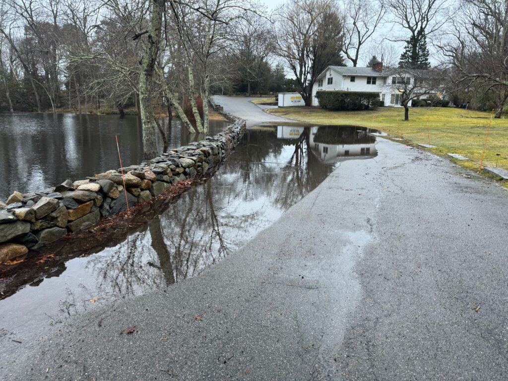a road with a small bridge over it and a house in the background (MyCoast AI)