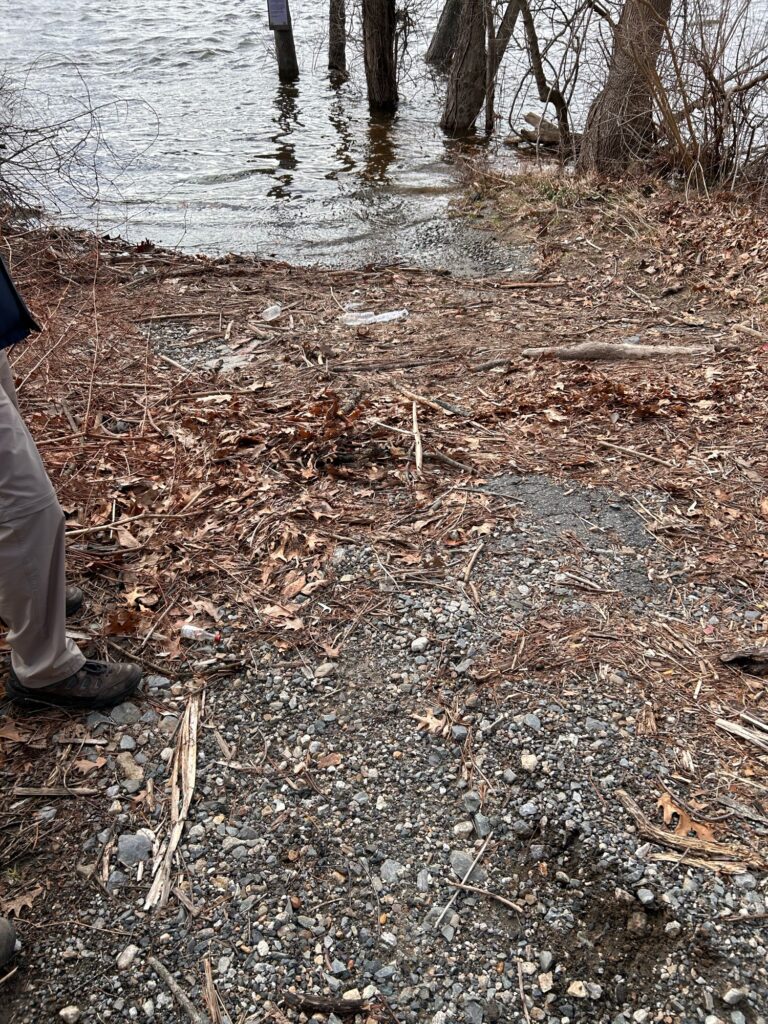 a person standing on a path by a river with trees (MyCoast AI)