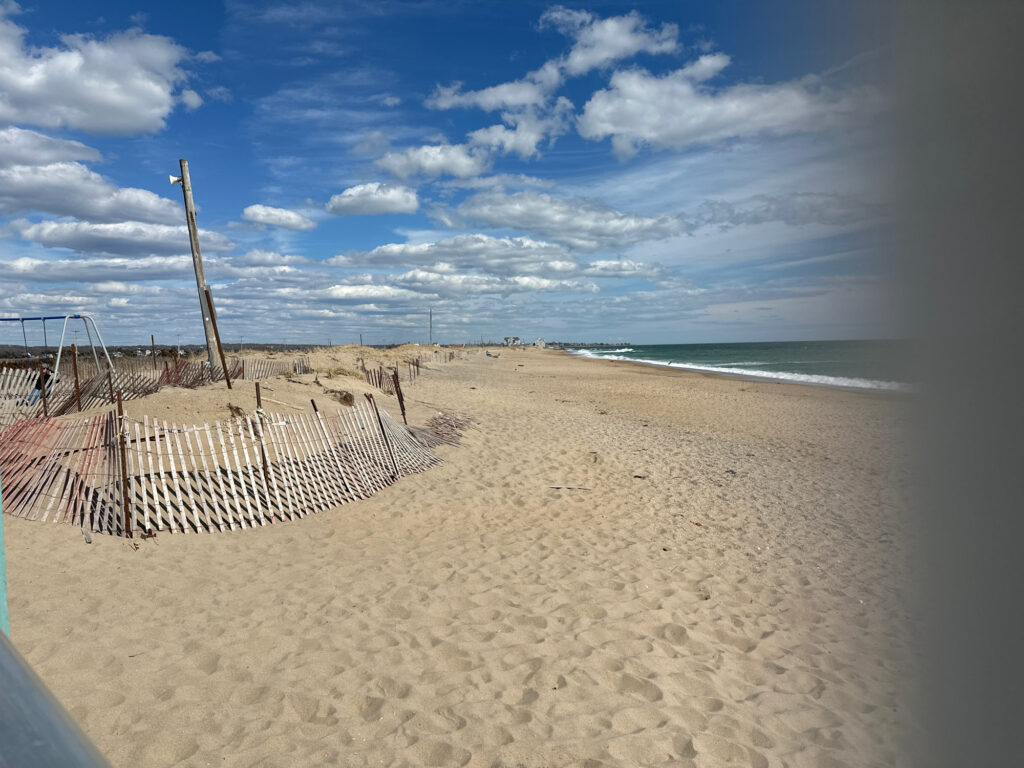 a beach with a fence and a body of water in the background (MyCoast AI)