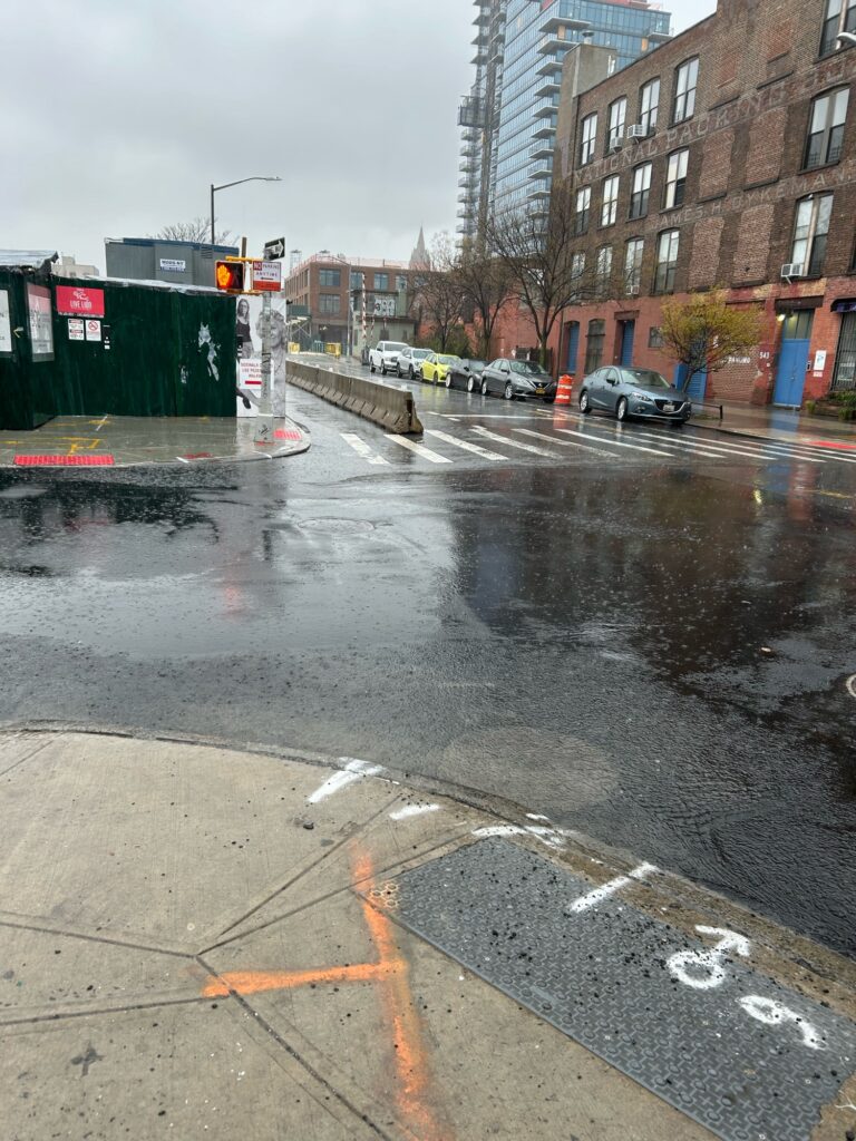a wet street with buildings on either side of it (MyCoast AI)