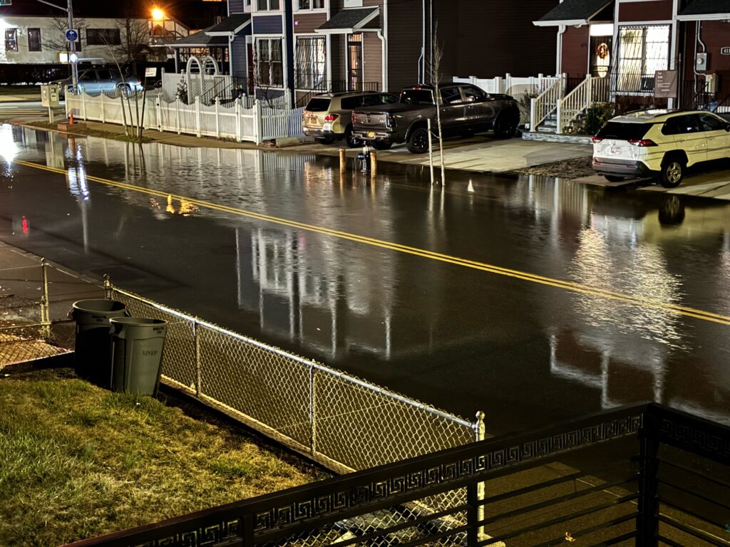 a wet street with cars parked on the side (MyCoast AI)