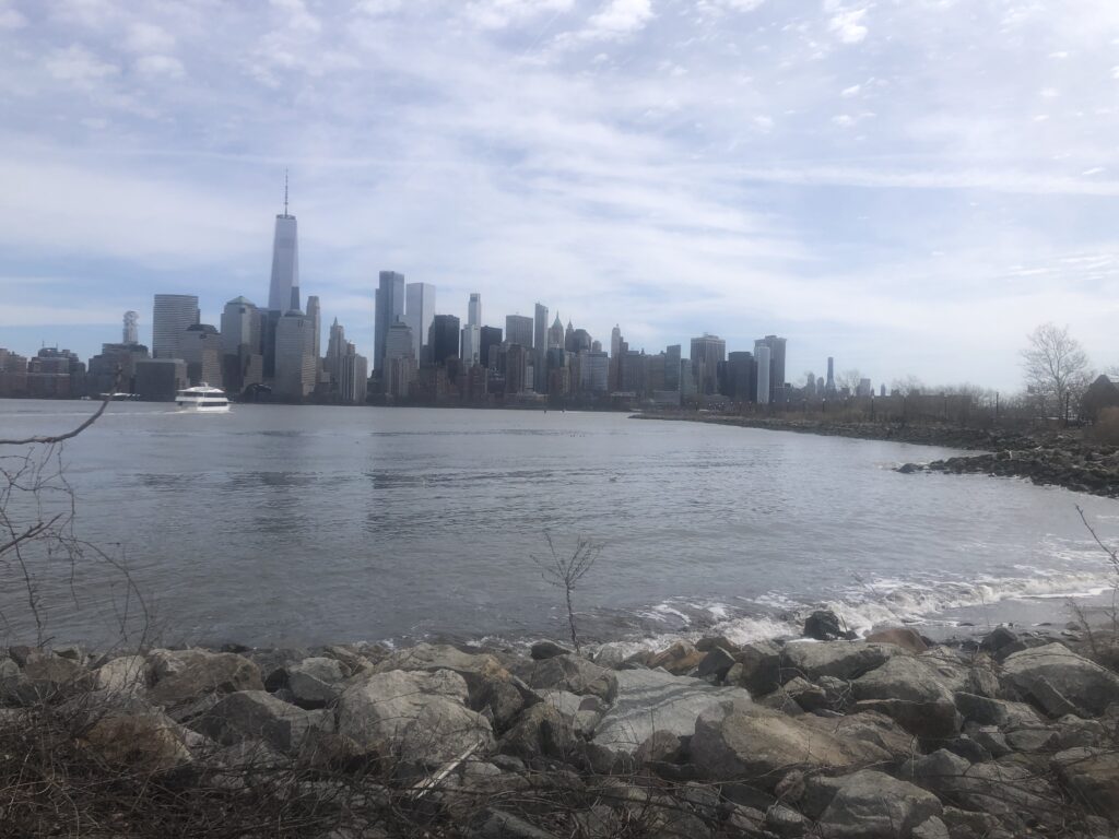 a body of water with rocks and a city in the background (MyCoast AI)