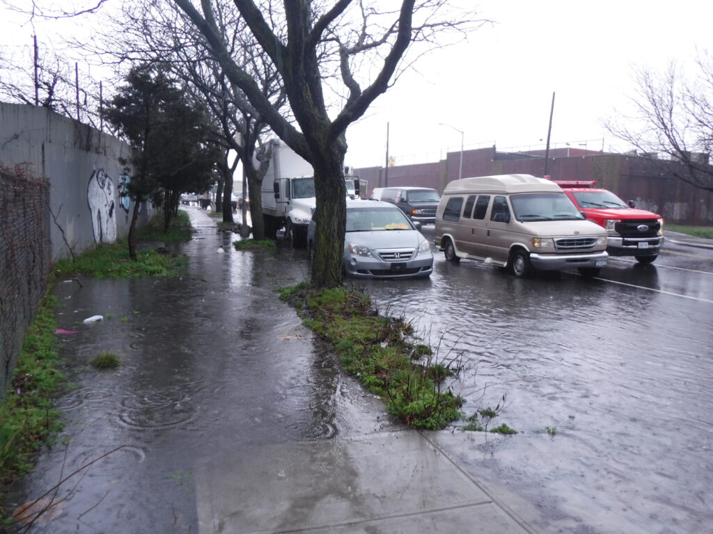 a flooded street with cars parked on the side (MyCoast AI)