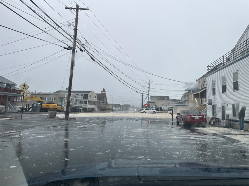 a wet street with buildings and cars (MyCoast AI)
