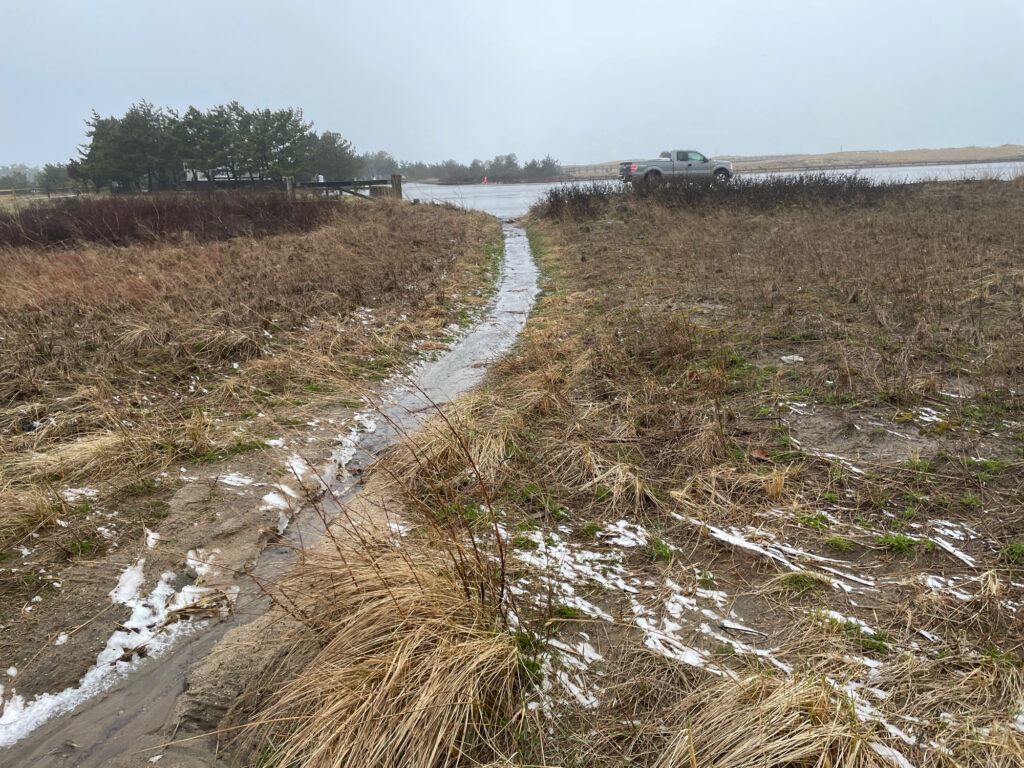 a muddy stream with a car on the side (MyCoast AI)