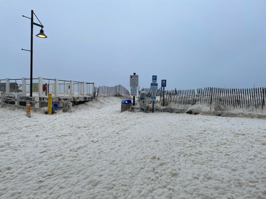a beach with a fence and a building in the distance (MyCoast AI)