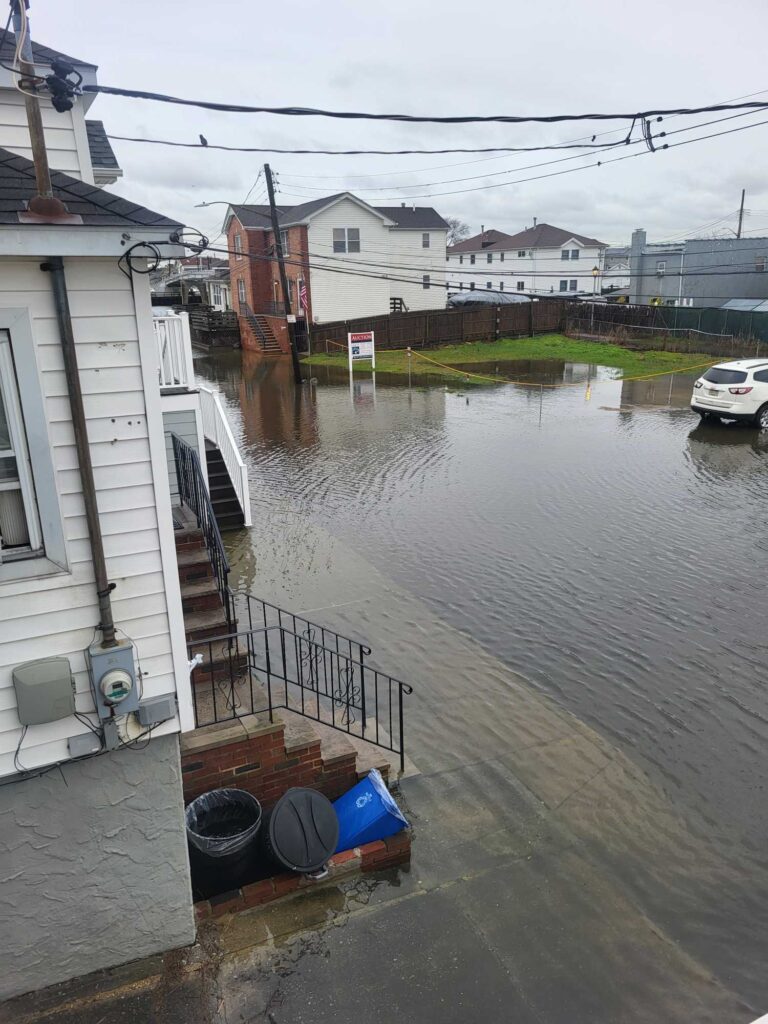 a flooded street with buildings and a boat (MyCoast AI)