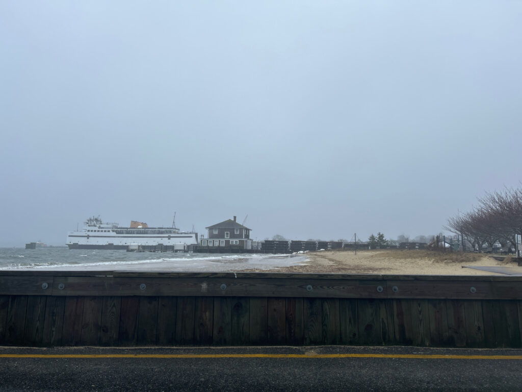 a road with a building on the side and a large ship in the distance (MyCoast AI)