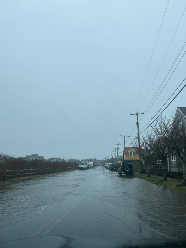 a flooded street with a car driving on it (MyCoast AI)