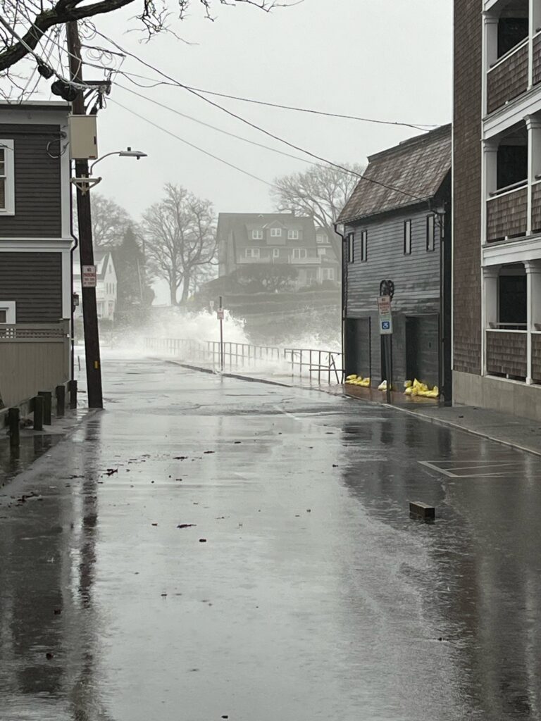 a wet street with buildings on either side of it (MyCoast AI)