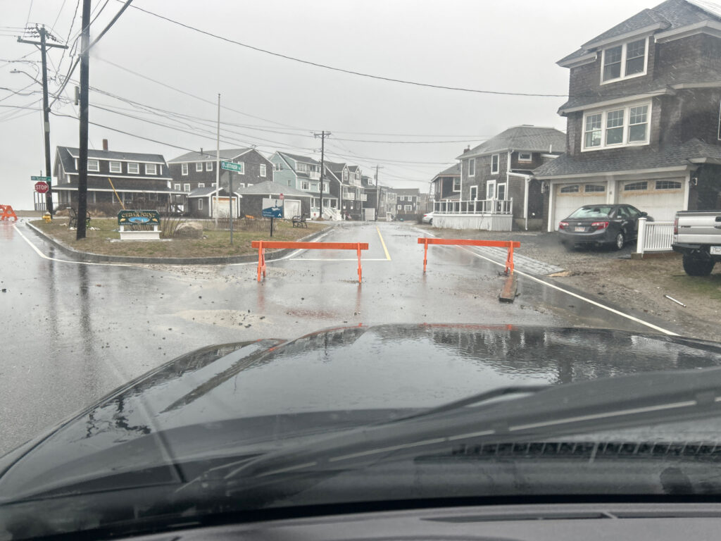 a road with a puddle on the side and houses on the side (MyCoast AI)