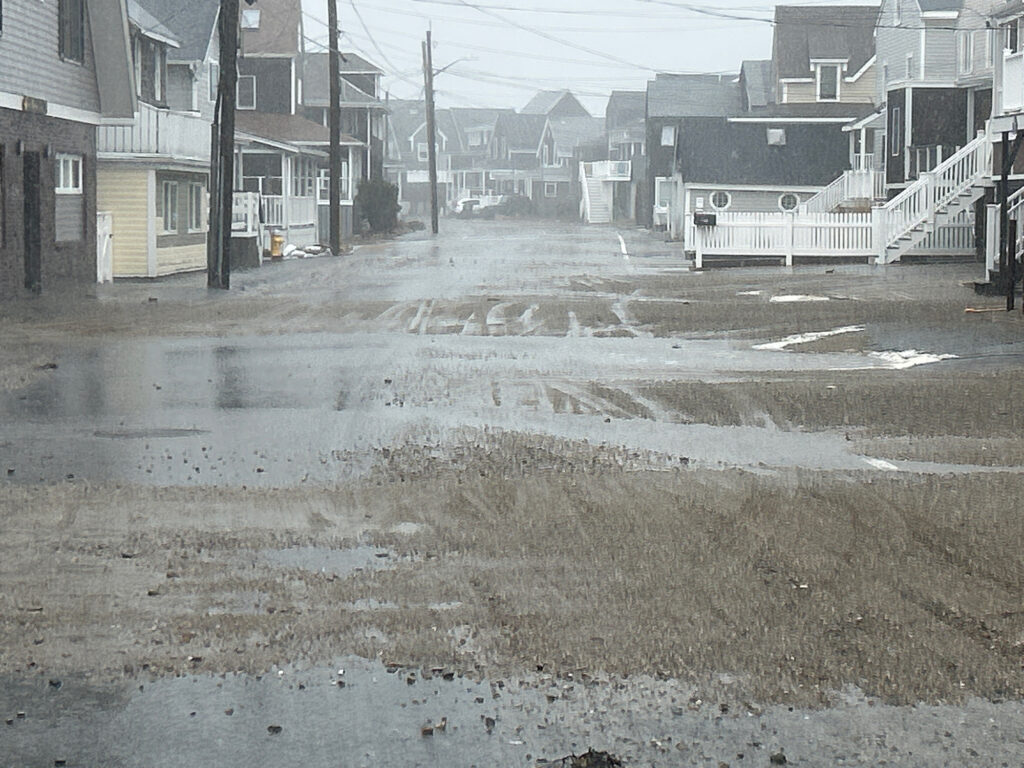 a wet street with houses on either side of it (MyCoast AI)