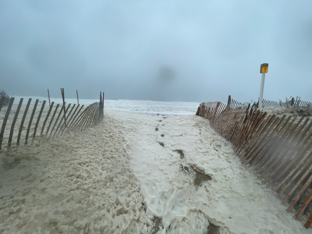 a snowy road with a fence and a beach with a sign (MyCoast AI)