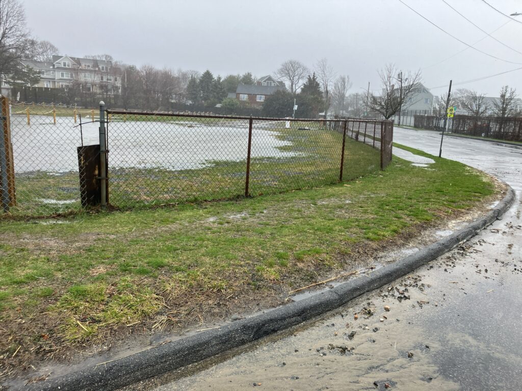 a fenced in field with a fence and a field with a house in the background (MyCoast AI)
