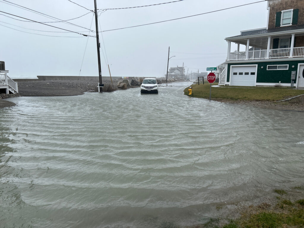a flooded street with a car driving through it (MyCoast AI)