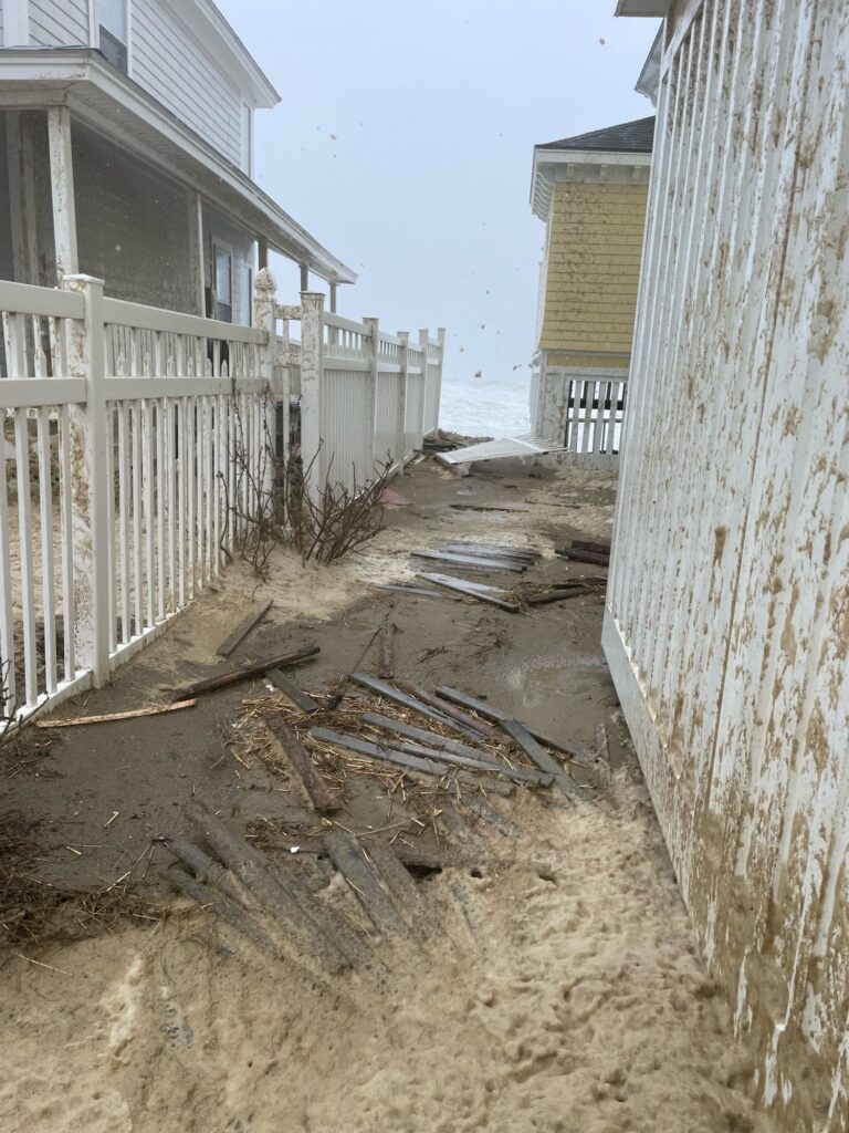 a sandy beach with a fence and a building (MyCoast AI)