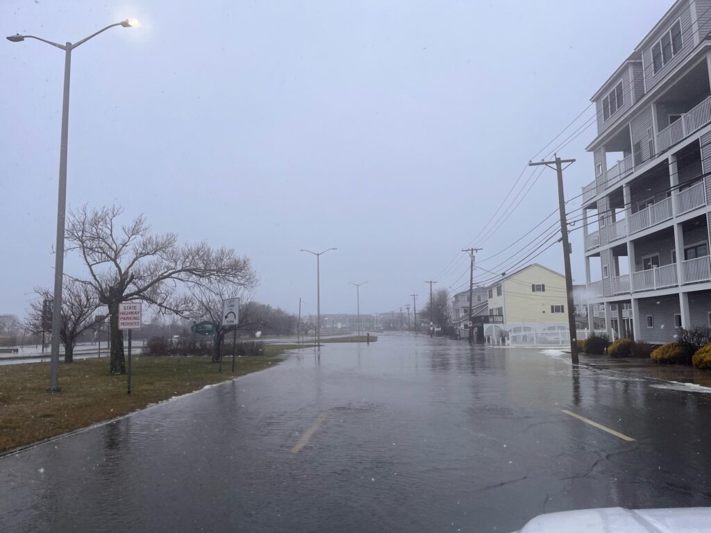a wet street with buildings on either side of it (MyCoast AI)