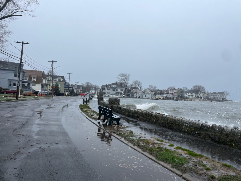 a person sitting on a bench by a road with snow on the side (MyCoast AI)