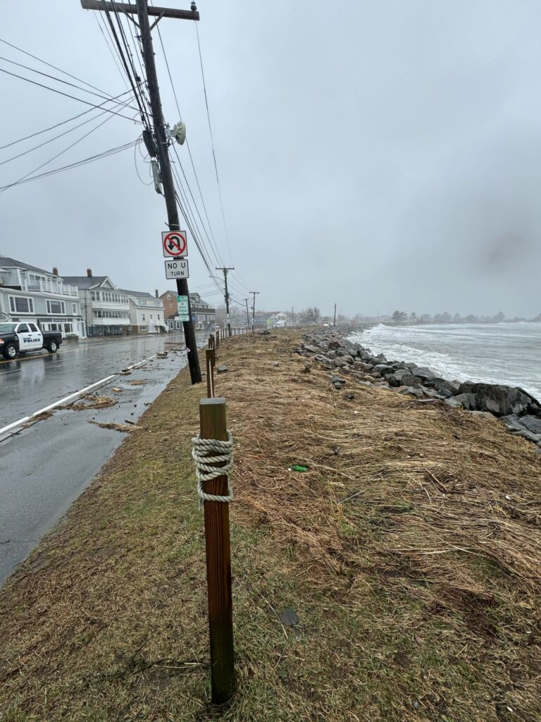 a road with a sign on it by a body of water (MyCoast AI)