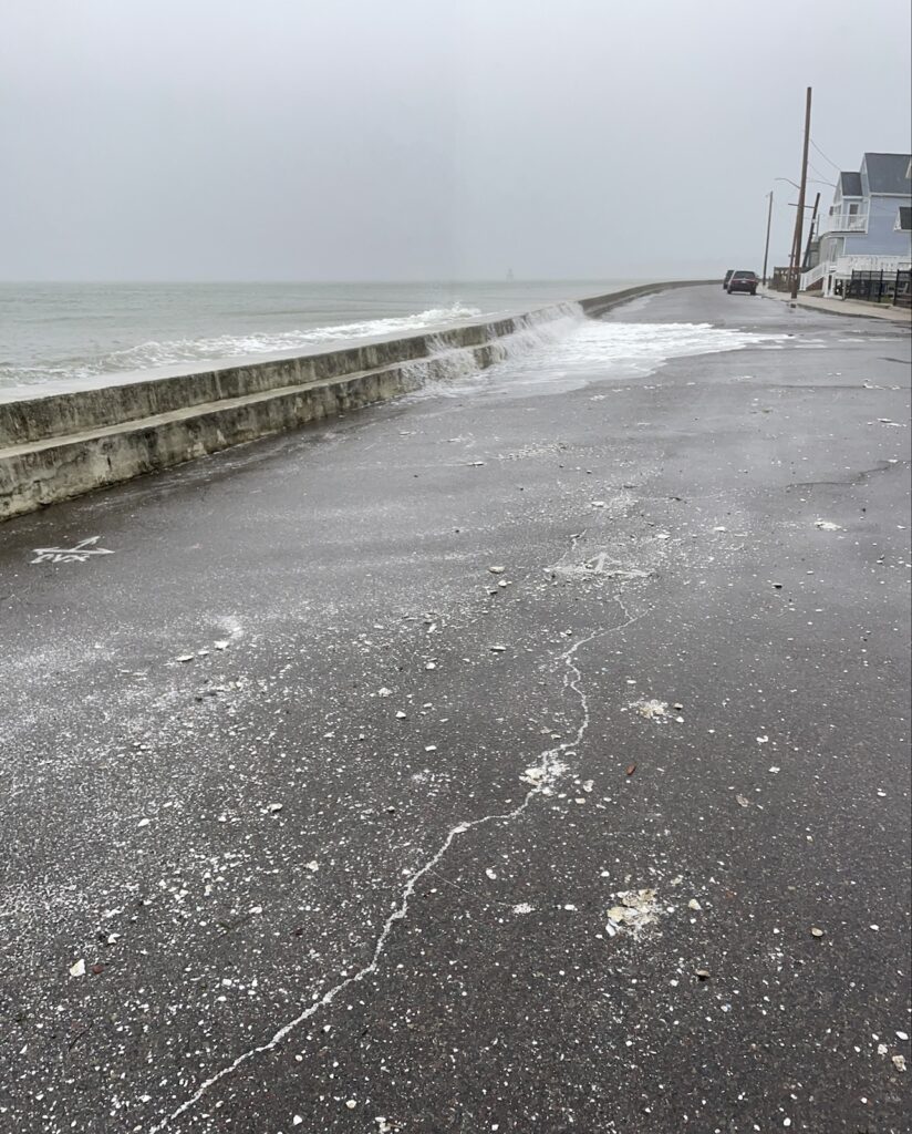 a wet road next to a beach (MyCoast AI)