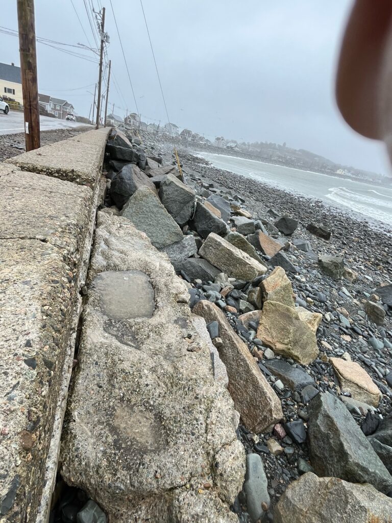 a rocky beach with a large rock wall (MyCoast AI)