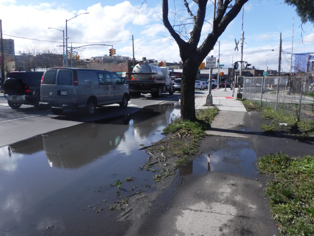 a flooded street with cars and trees (MyCoast AI)