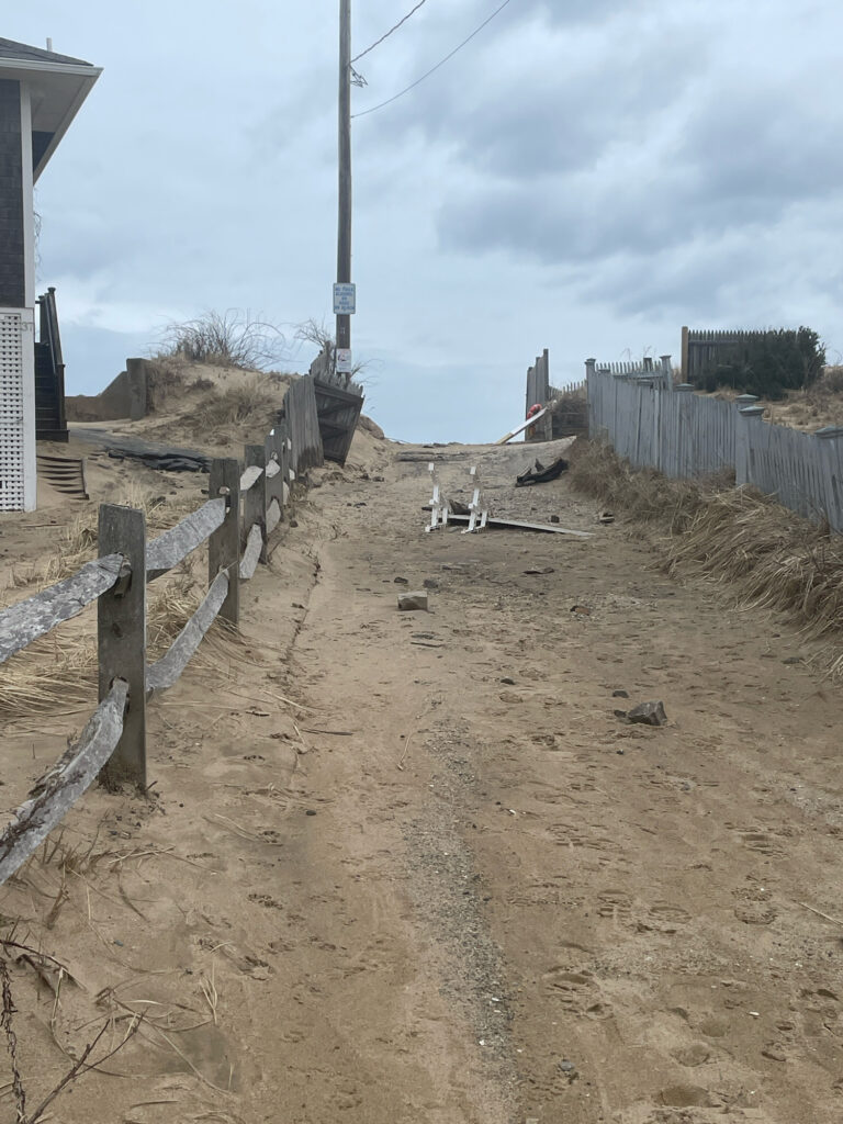 a dirt road with a fence and a building on the side (MyCoast AI)