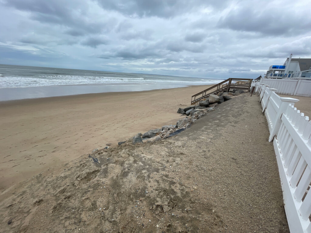 a sandy beach with a white fence (MyCoast AI)