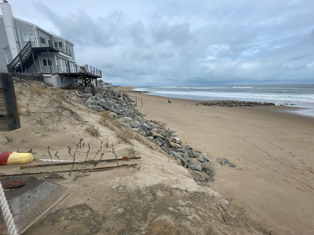a beach with rocks and a building (MyCoast AI)