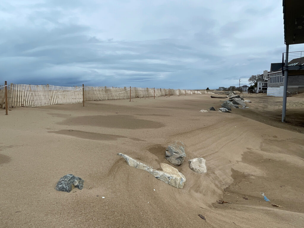 a dirt area with a fence and rocks in the background (MyCoast AI)