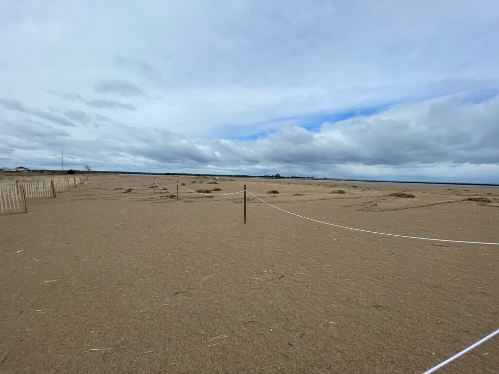 a sandy area with a fence and a wire fence (MyCoast AI)