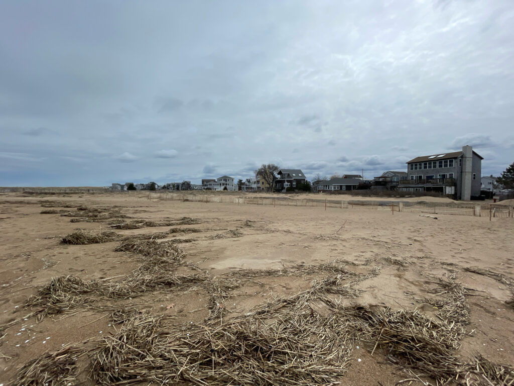 a large dirt field with buildings in the background (MyCoast AI)