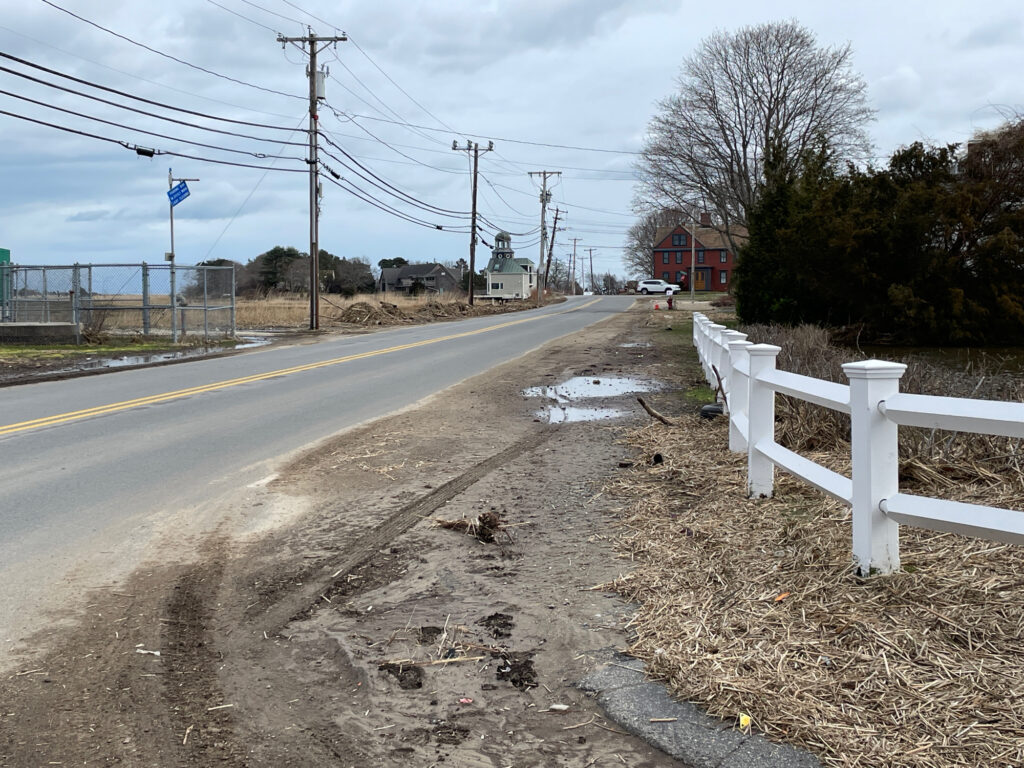 a road with a fence and a white picket fence (MyCoast AI)