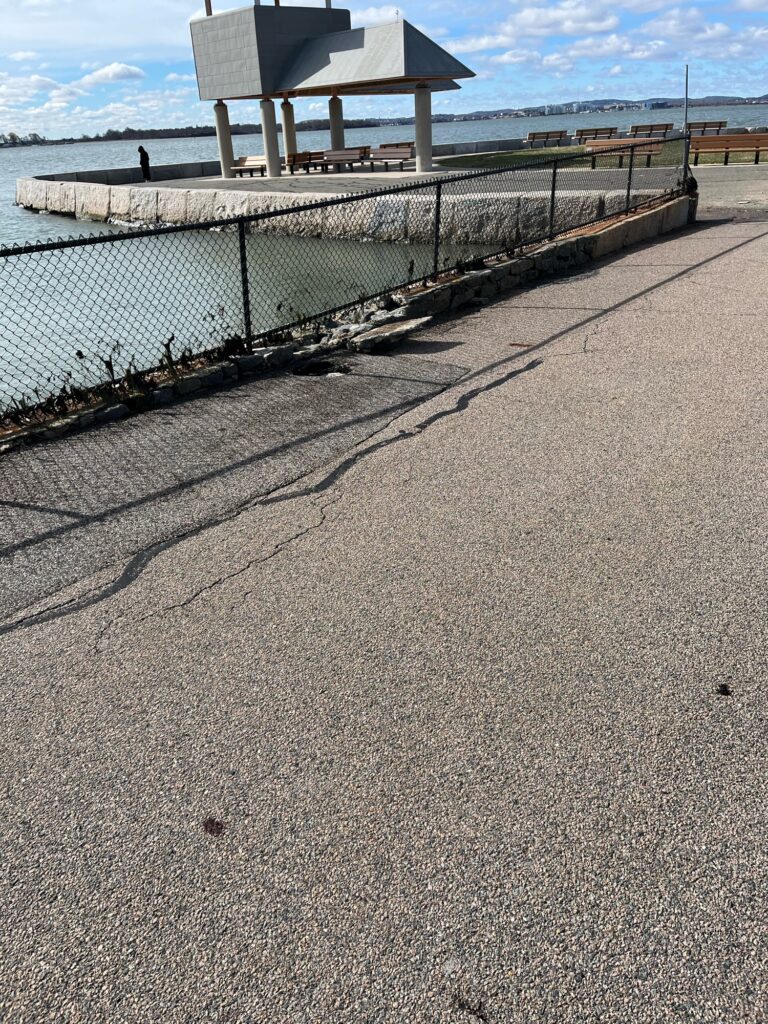 a concrete walkway next to a body of water (MyCoast AI)