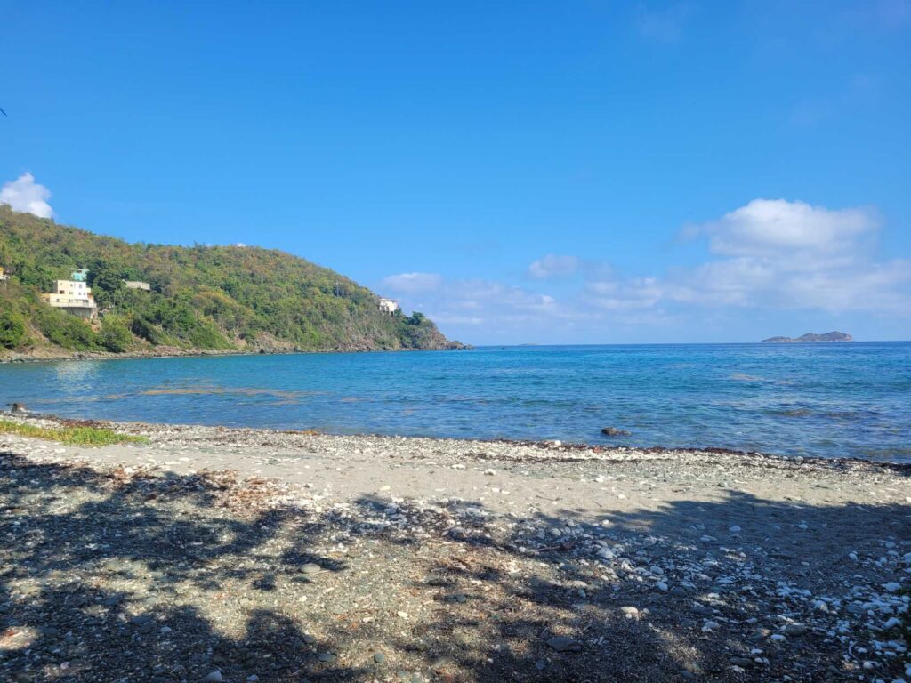 a beach with a hill and water (MyCoast AI)