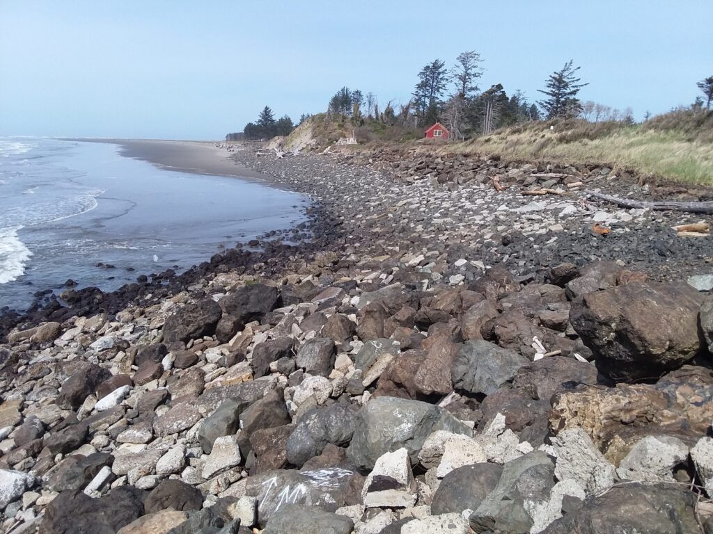 a rocky beach with a red house (MyCoast AI)