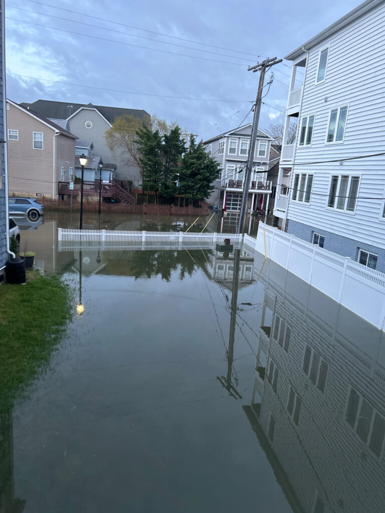 a flooded street between buildings (MyCoast AI)