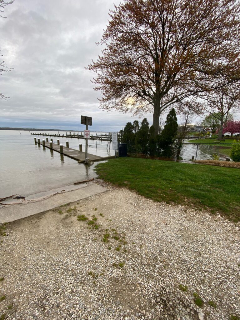 a path next to a body of water with a bridge in the distance (MyCoast AI)