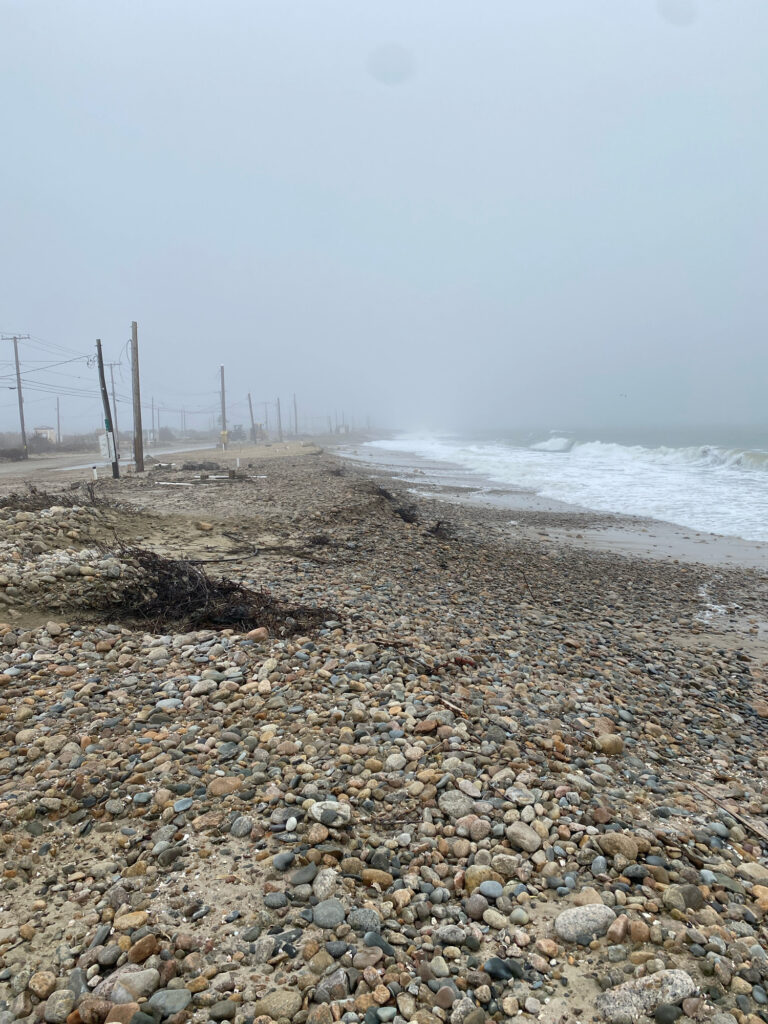 a rocky beach with a fence and waves crashing on it (MyCoast AI)