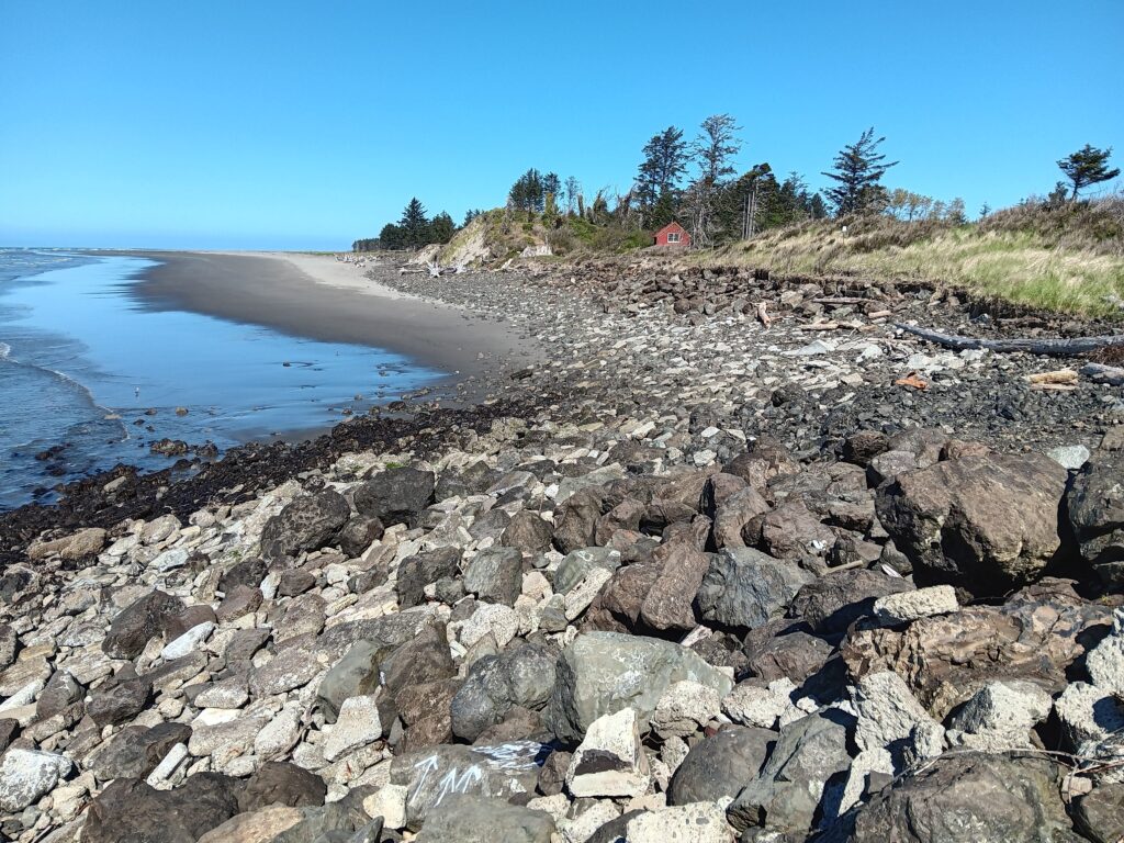 a rocky beach with a small house (MyCoast AI)