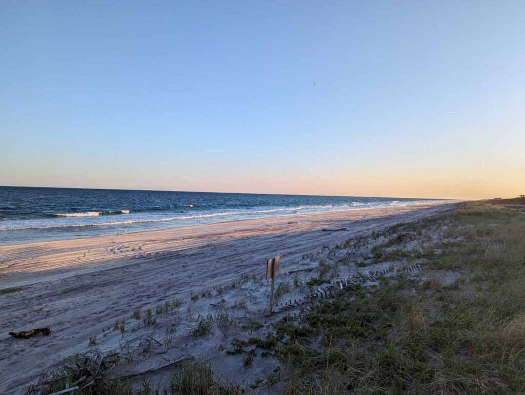 a sandy beach with grass and water (MyCoast AI)