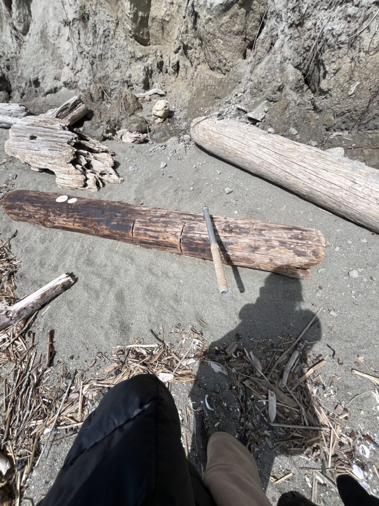 a person's legs and a wooden cross on the ground (MyCoast AI)